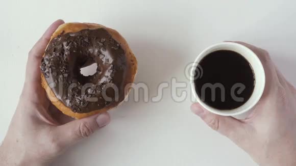 男人手拿着甜甜圈和咖啡顶部视图视频的预览图