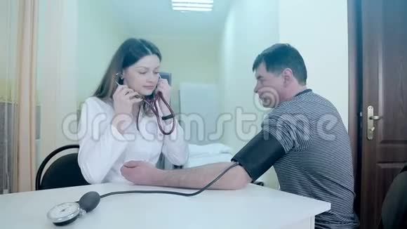医生是一个在医疗室测量病人压力的女人视频的预览图