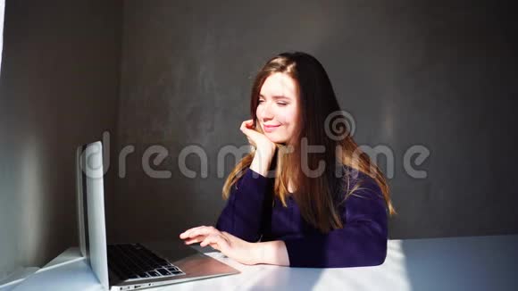 年轻女孩在旅行时在笔记本电脑上看照片视频的预览图