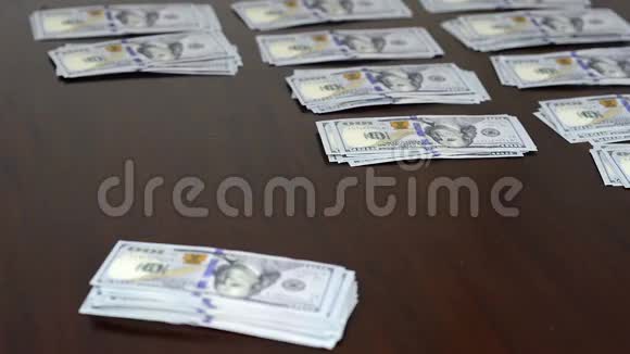 男人办公桌上数着钱把钞票叠成百美元钞票视频的预览图