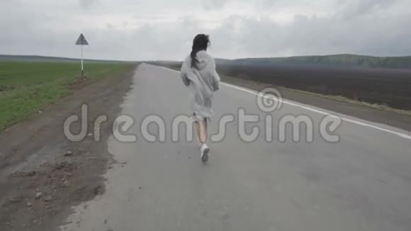 女人在空荡荡的乡村道路上奔跑视频的预览图