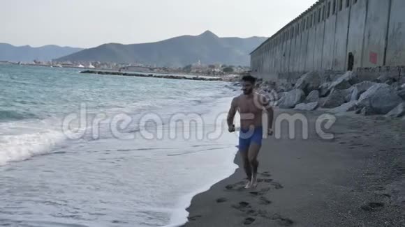 年轻人在海滩上锻炼慢跑和跑步视频的预览图