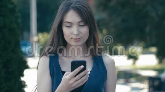 街头背景下使用智能手机的年轻美女画像视频的预览图