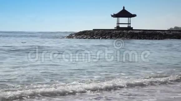 在阳光明媚的日子里在热带海滩岸边蓝天的背景下传统的民族乔木巴厘视频的预览图