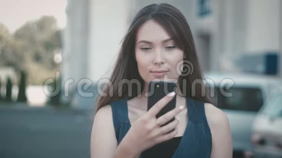 街头背景下使用智能手机的年轻美女画像视频的预览图
