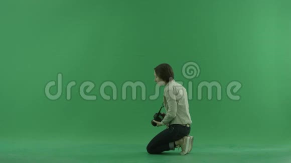 坐着的年轻女子正在绿色屏幕上左手边拍宏观照片视频的预览图