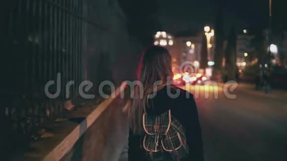 车水马龙时深色头发的女人走在路边女孩一个人在深夜穿过城市视频的预览图