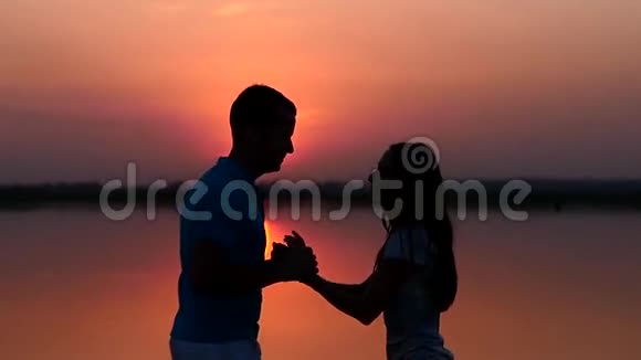 剪影男人和女人在日落时跳舞慢慢视频的预览图