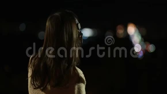 戴耳机的女人晚上听音乐视频的预览图