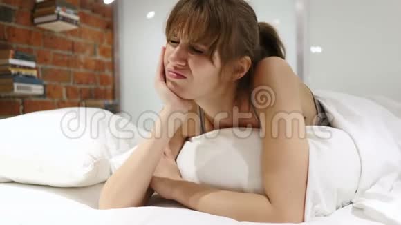 患牙疼痛牙痛躺在床上的沮丧妇女视频的预览图