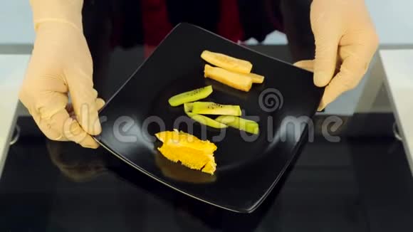 厨师把一盘寿司配料放在桌子上寿司猕猴桃橘子鳄梨的配料视频的预览图
