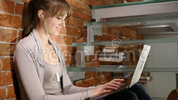 青年妇女与朋友的视频聊天坐在楼梯上视频的预览图