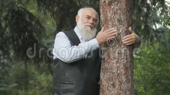 英俊的老人拥抱树干的肖像视频的预览图
