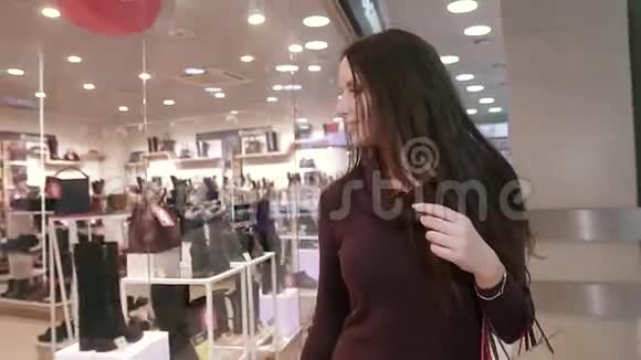 购物中心漂亮的微笑女人在看商品视频的预览图