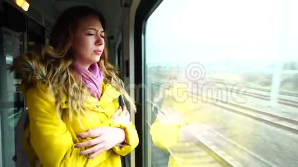 秋天的下午迷人的女性旅行者在大的运输窗口附近离开和站在火车上感到悲伤视频的预览图