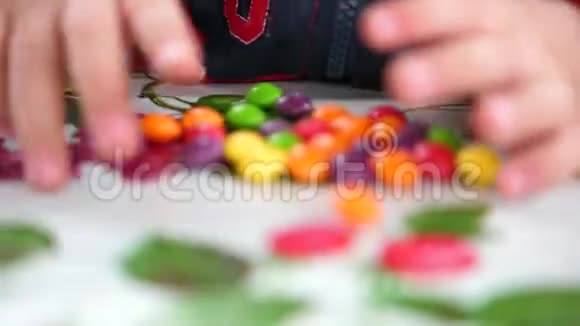 小小的彩色糖果孩子们的手从桌子上拿糖果视频的预览图