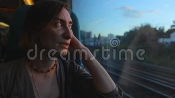中年妇女坐在火车的窗户附近看着并思考着未来视频的预览图