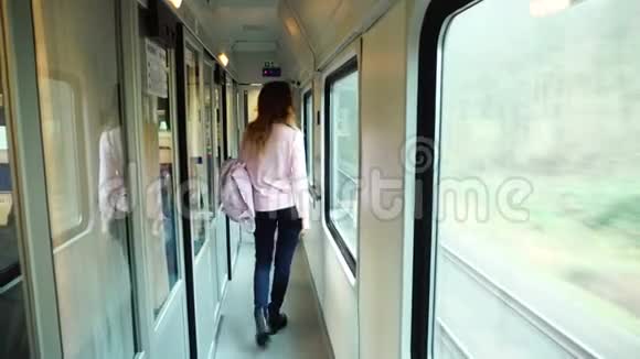 可爱的年轻女子沿着移动的火车走廊旅行早上前往出口视频的预览图