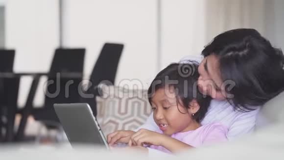 年轻女子和女儿使用笔记本电脑视频的预览图