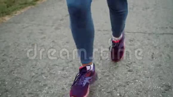 那个女孩沿着沥青路跑腿部特写视频的预览图