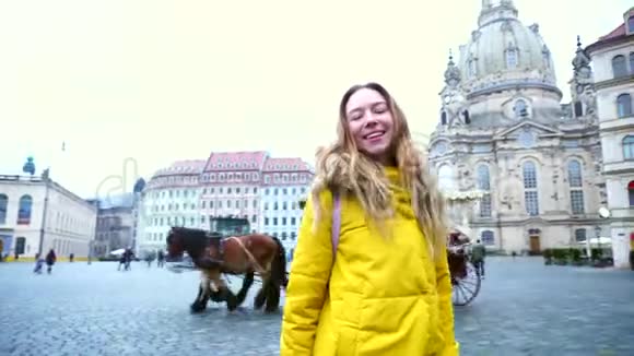 在美丽的欧洲城市德累斯顿在美丽的风景中微笑的女人在镜头中行走和摆姿势的肖像视频的预览图