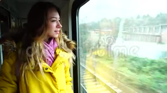 秋天的下午年轻女子在车站等火车驶近城市视频的预览图