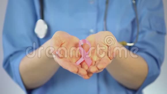 女医生手掌上的粉红色丝带乳腺癌宣传运动视频的预览图