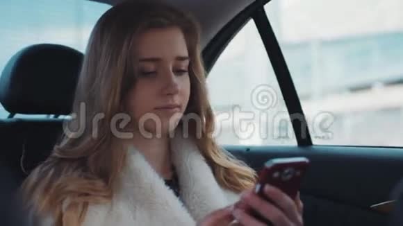 近距离观看迷人的金发女孩拿着手机坐在割草车里上网视频的预览图