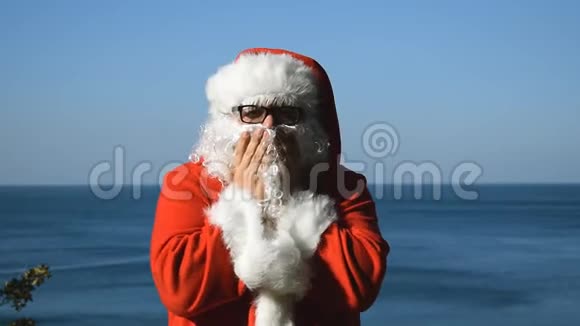 海边一个穿着圣诞老人服装的男人热带的圣诞节视频的预览图
