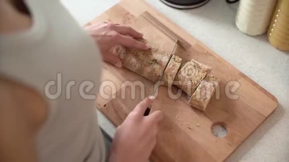 用女人的手在木板上切面包视频的预览图