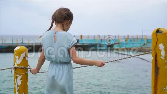 暑假期间在海滩可爱的小女孩有海景的孩子的后景流动人口视频的预览图
