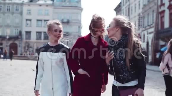 三个年轻时尚的女人在市中心散步说话笑时尚的外观令人惊叹的红色外套真实视频的预览图