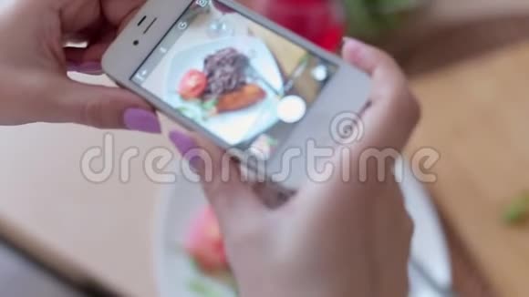 女人用智能手机拍照晚餐食物视频的预览图