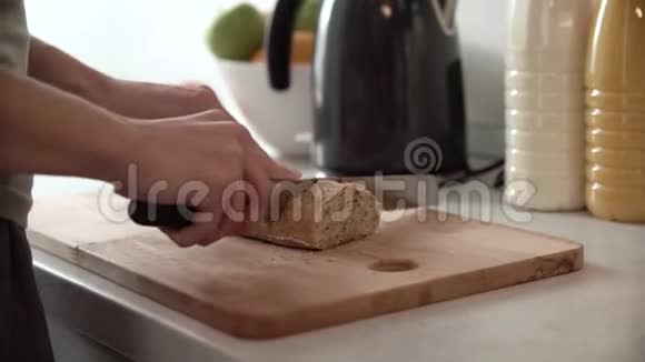 用女人的手在木板上切面包视频的预览图