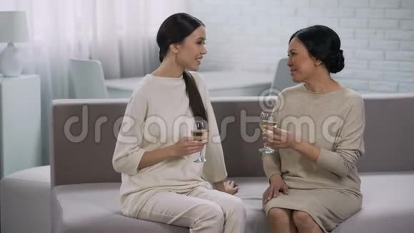 两个快乐的亚洲女人喝白葡萄酒庆祝胜利合作视频的预览图