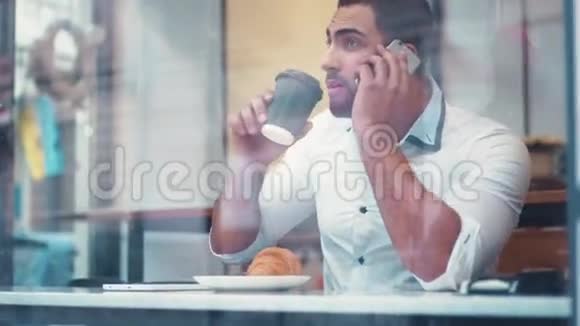 商人在咖啡馆的窗口边喝咖啡在谈话结束后一个人打电话视频的预览图