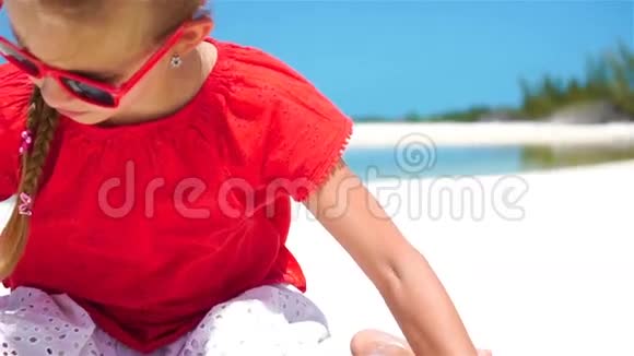 暑假期间在海滩上可爱的小女孩的肖像快乐的孩子玩沙子慢动作视频的预览图