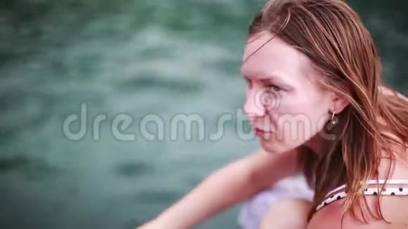 年轻女子用一块面包在海里喂小鱼在炎热的晴天假期1920x1080视频的预览图