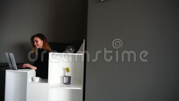 可爱女孩的肖像在电脑键盘上打印的主要邮件列表坐在现代的餐桌上视频的预览图