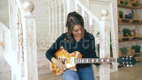 有魅力的年轻女孩学弹电吉他楼梯上学弹电吉他视频的预览图