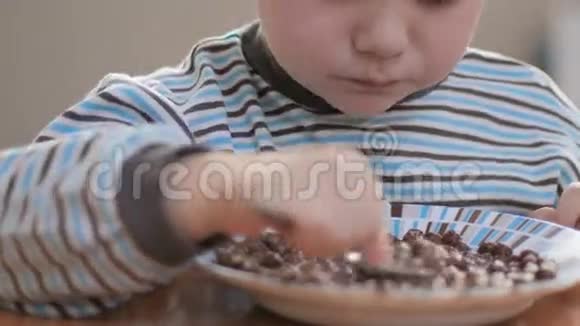 特写镜头男孩在家吃带牛奶的薄片视频的预览图