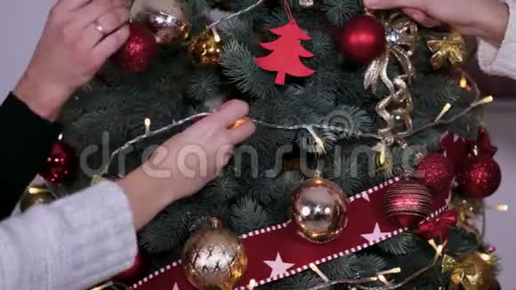 把圣诞玩具挂在圣诞树上的人的特写视频的预览图