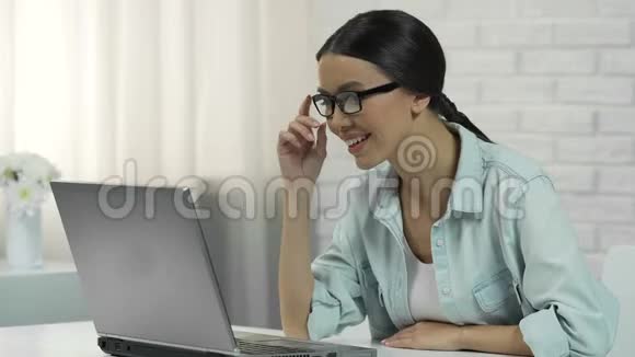 戴眼镜的亚洲女人在社交网络上聊天微笑着回答信息视频的预览图