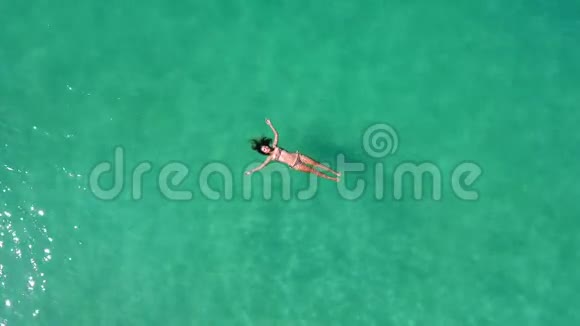 美丽的年轻女子游泳躺在晶莹剔透的海面上高清空中慢动作镜头泰国视频的预览图