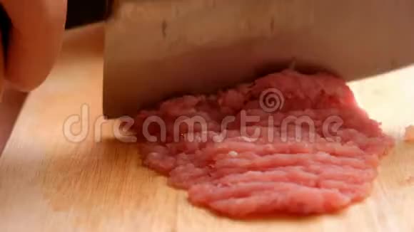 厨师正用锋利的刀在木切割板上切生猪肉以便在厨房里做饭视频的预览图