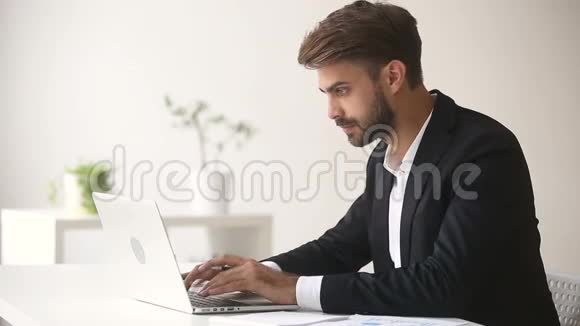 年轻商人用笔记本电脑在办公桌上打电话视频的预览图