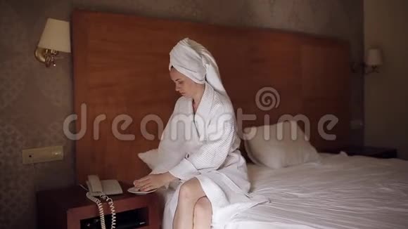 淋浴后一位穿浴袍的女士喝咖啡打电话到接待处视频的预览图