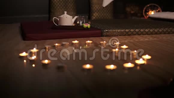 充满激情的心蜡烛呈心形排列心形的发光蜡烛背面有茶壶视频的预览图