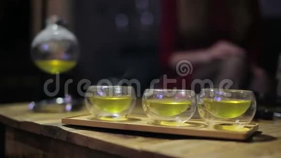 在茶道上双手合拢端起小杯茶视频的预览图