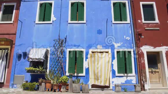 漂亮的花盆装饰着蓝色房子的简陋门面贫穷视频的预览图